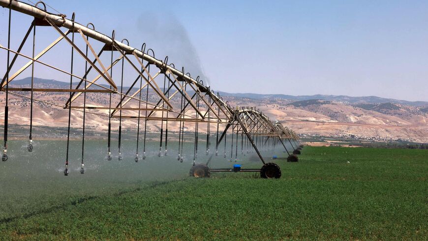 A picture taken on July 21, 2021, shows a center-pivot irrigation system spraying water in agricultural fields near the border with Jordan (background), south of the Sea of Galilee, or Lake Tiberias, one of the main water sources in Israel. As scientific warnings of dire climate change-induced drought grow, many in Israel and Jordan cast worried eyes at the river running between them and the critical but limited resources they share. (Photo by MENAHEM KAHANA / AFP) (Photo by MENAHEM KAHANA/AFP via Getty Ima