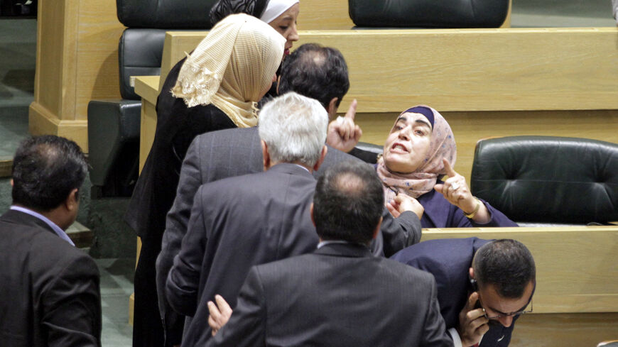 Jordanian parliament members are separated during an altercation in the parliament in the capital Amman on December 28, 2021. (Photo by AFP) (Photo by -/AFP via Getty Images)