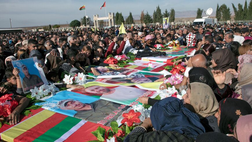 Relatives mourn over the caskets of 11 people killed in Turkish airstrikes.