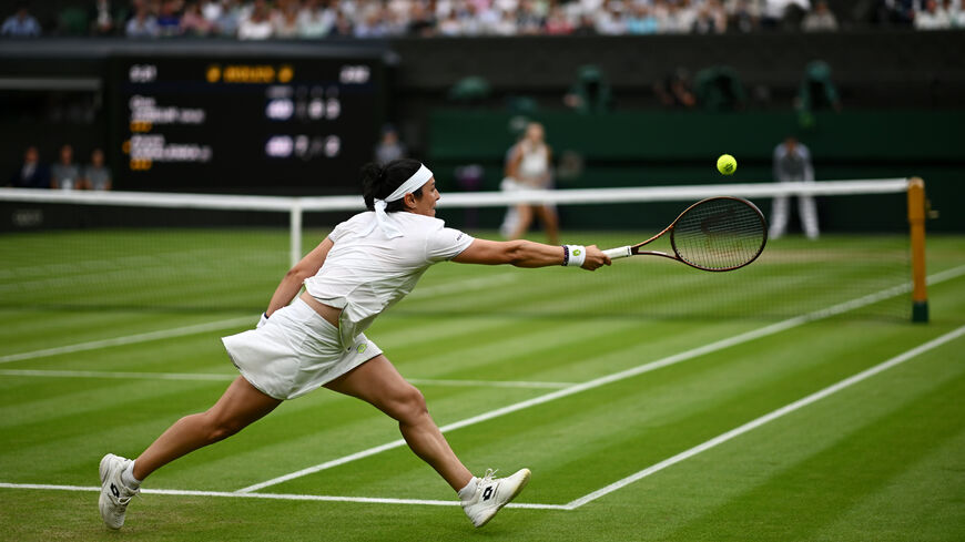 Ons Jabeur of Tunisia stretches to make a forehand against Aryna Sabalenka in the Women's Singles Semi Finals on day eleven of The Championships Wimbledon 2023 at All England Lawn Tennis and Croquet Club on July 13, 2023 in London, England. (Photo by Mike Hewitt/Getty Images)